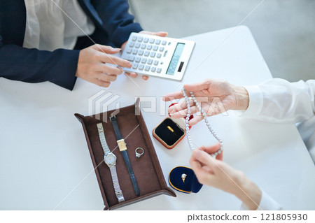 一位採購專家和一位中年婦女正在評估貴金屬 121805930