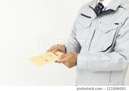 A man wearing work clothes and holding a pay envelope, white background 121806091
