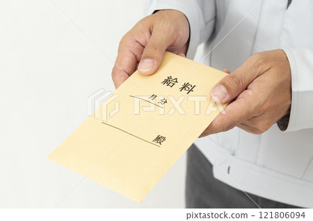 Hand holding pay envelope on white background 121806094
