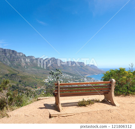 Bench with a beautiful view of Table Mountain and sea against a clear blue sky background with copy space. Relaxing spot for a peaceful break to enjoy the scenic landscape after a hike up a cliff 121806312