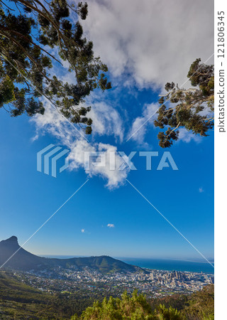 Beautiful view of a cityscape, nature and Table Mountain in Cape Town, South Africa against a cloudy blue sky with copy space. Landscape of a popular tourist town with greenery during summer 121806345