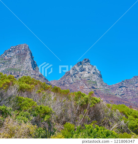 Famous mountain hiking destination with copy space, green forest trees and woods in Cape Town, South Africa. Landscape view of the Twelve Apostles Mountains with blue sky in a serene nature reserve Famous mountain hiking destination with copy space, green forest trees and woods in Cape Town, South Africa. Landscape view of the Twelve Apostles Mountains with blue sky in a serene nature reserve 121806347