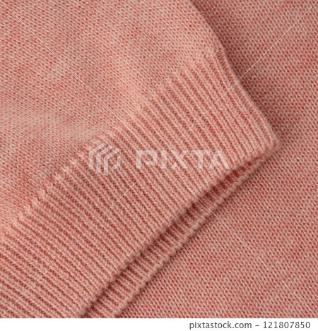 Elastic band close up on the sleeve of a salmon pink knitted cotton polo t-shirt Elastic band close up on the sleeve of a salmon pink knitted cotton polo t-shirt 121807850