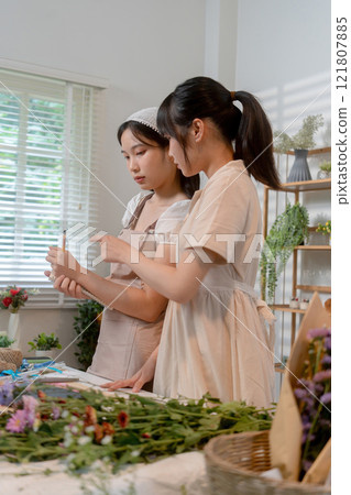 Gardeners florist at her own floral shop taking care of flowers. Gardeners florist at her own floral shop taking care of flowers. 121807885