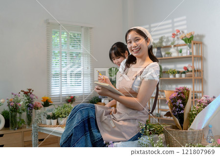 Gardeners florist at her own floral shop taking care of flowers. Gardeners florist at her own floral shop taking care of flowers. 121807969