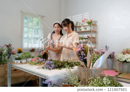 Gardeners florist at her own floral shop taking care of flowers. 121807981