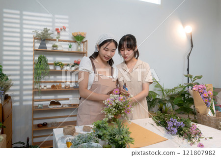 Gardeners florist at her own floral shop taking care of flowers. 121807982