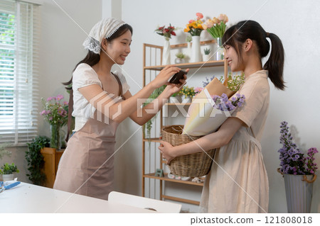 Gardeners florist at her own floral shop taking care of flowers. Gardeners florist at her own floral shop taking care of flowers. 121808018