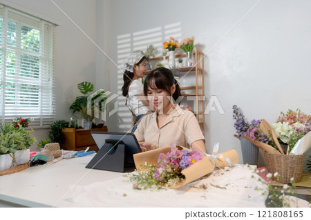Gardeners florist at her own floral shop taking care of flowers. Gardeners florist at her own floral shop taking care of flowers. 121808165