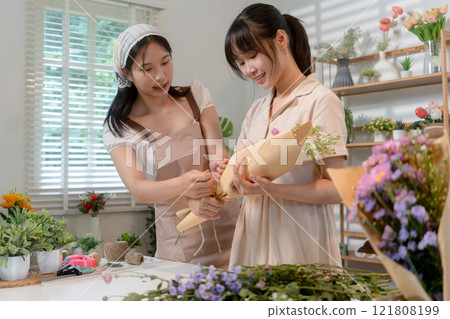 Gardeners florist at her own floral shop taking care of flowers. 121808199