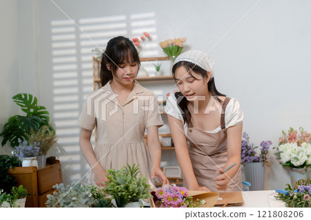 Gardeners florist at her own floral shop taking care of flowers. 121808206