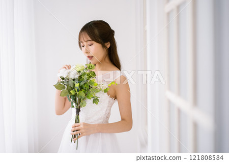 A young woman with long black hair wearing a wedding dress A young woman with long black hair wearing a wedding dress 121808584