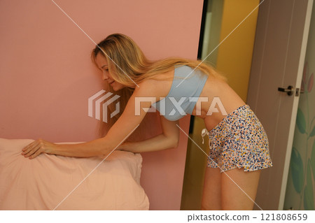 A young woman is enjoying a wonderfully serene morning in her bedroomnd  121808659