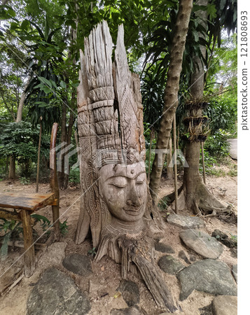 A stunning and beautiful tree sculpture showcasing a serene face 121808693