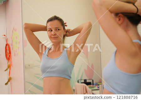 Young woman in a modern bathroom washing her face and brushing her teeth Young woman in a modern bathroom washing her face and brushing her teeth 121808716