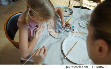 A young mother and her daughter enjoy a creative art session at home A young mother and her daughter enjoy a creative art session at home 121808789