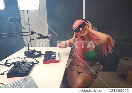 Beautiful young singer and musician broadcast from her home studio 121808965
