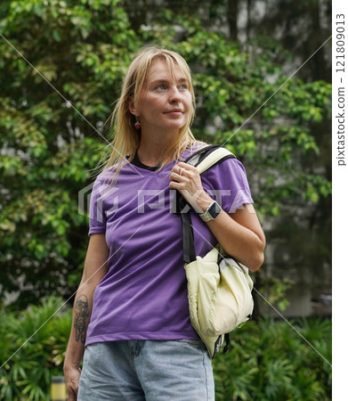 A woman is rollerblading gracefully on a road located in a park 121809013