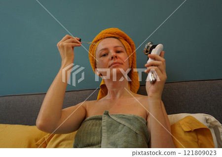 Young woman using infrared massager  121809023