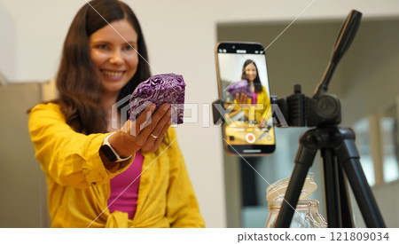 Young woman is broadcasting live from workshop how to prepare a vegetarian food 121809034