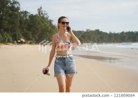 A young woman enjoying a beautiful day at the beach  121809084