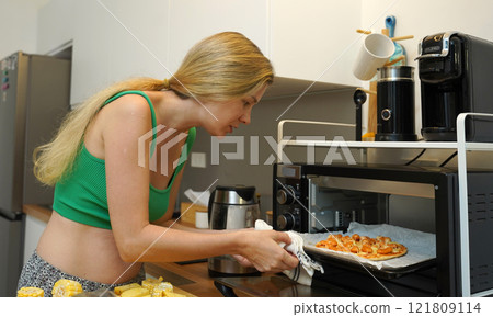 A young woman joyfully prepares a variety of healthy meals A young woman joyfully prepares a variety of healthy meals 121809114