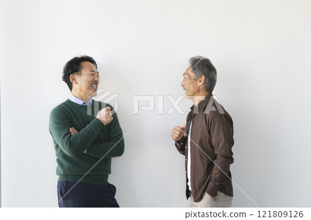Two senior men smiling and chatting Two senior men smiling and chatting 121809126