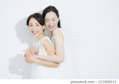 Two cuddling women 121809213