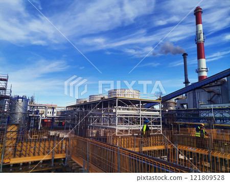 Steel structure is under construction on the construction site against a blue sky backdrop Steel structure is under construction on the construction site against a blue sky backdrop 121809528