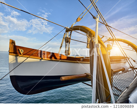 A lifeboat is securely tied to the mast of a sailing vessel 121809889