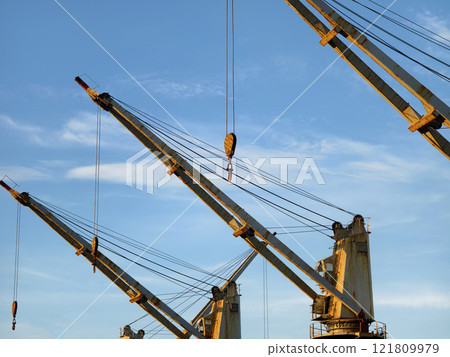A large ship equipped with cranes mounted on its side 121809979