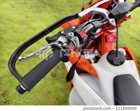 A detailed close up view focusing on the handlebars of a dirt bike A detailed close up view focusing on the handlebars of a dirt bike 121809999