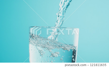 Clear Water Pouring into Glass Cup with Ripples and Reflections on Light Blue Background 121811635