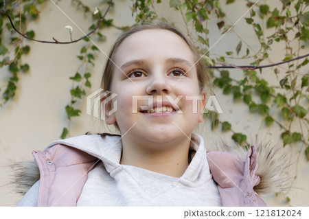 Close-up portrait of child smiling outdoors. Happiness and childhood concept 121812024