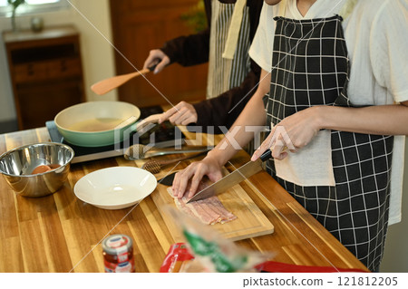 Close up of a gay couple preparing a meal in the kitchen 121812205