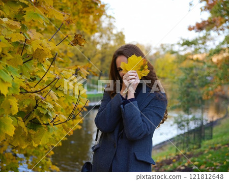 Girl, autumn image near yellow leaves in gray coat. Riga, Latvia Girl, autumn image near yellow leaves in gray coat. Riga, Latvia 121812648