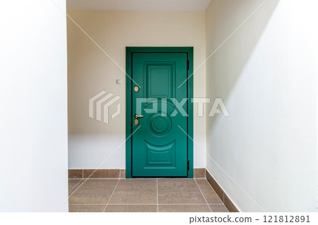 Entrance to the apartment with a modern green door 121812891