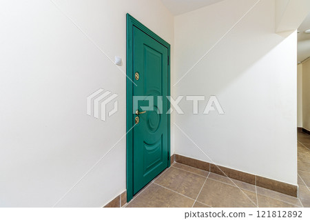 Entrance to the apartment with a modern green door 121812892