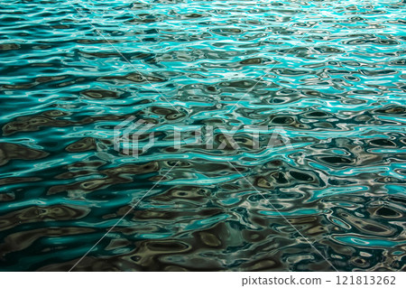 Water ripple texture background. Wavy water surface during sunset, golden light reflecting in water. Water ripple texture background. Wavy water surface during sunset, golden light reflecting in water. 121813262
