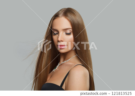 Glamorous young woman model with modern make-up and long straight smooth hairstyle standing  121813525
