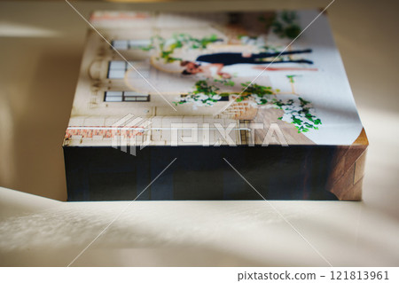 a closed photo book with wedding photos on a white table a closed photo book with wedding photos on a white table 121813961