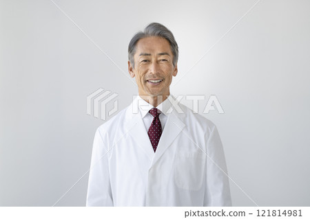 Senior man in white coat smiling at camera 121814981