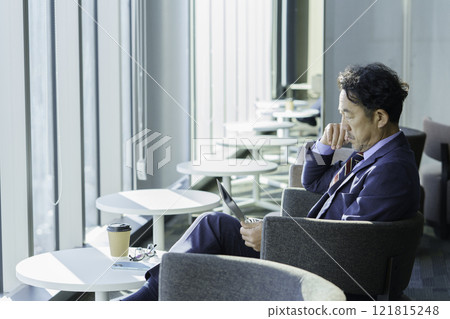 坐在椅子上操作筆記型電腦的中年男子 攝影合作：電波學園教育株式會社、東京電子學校。 121815248