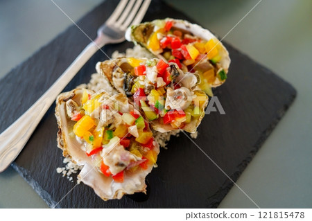 Oysters Rockefeller with diced vegetables served on the half shell Oysters Rockefeller with diced vegetables served on the half shell 121815478
