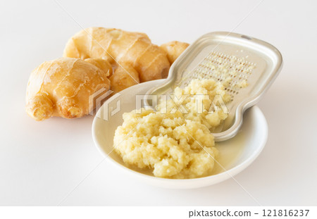 Grated ginger: Grated ginger using a grater 121816237