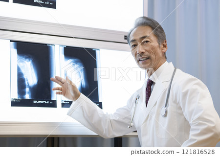 A veteran doctor explaining an X-ray of a shoulder joint 121816528