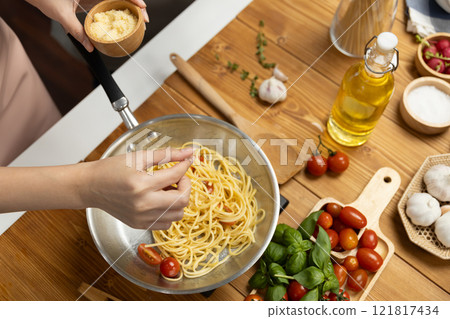 Close up influencer cooking spaghetti mix ingredient to frying pan. Postulate. 121817434