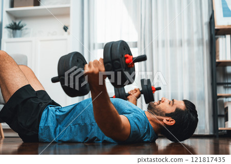 Athletic body and active sporty man lifting dumbbell at gaiety home exercise. 121817435