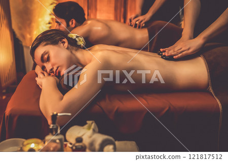 Hot stone massage at spa salon in luxury resort with warm candle light.Quiescent 121817512