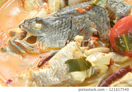 boiled bass fish head and mushroom in tom yum soup on plate 121817540